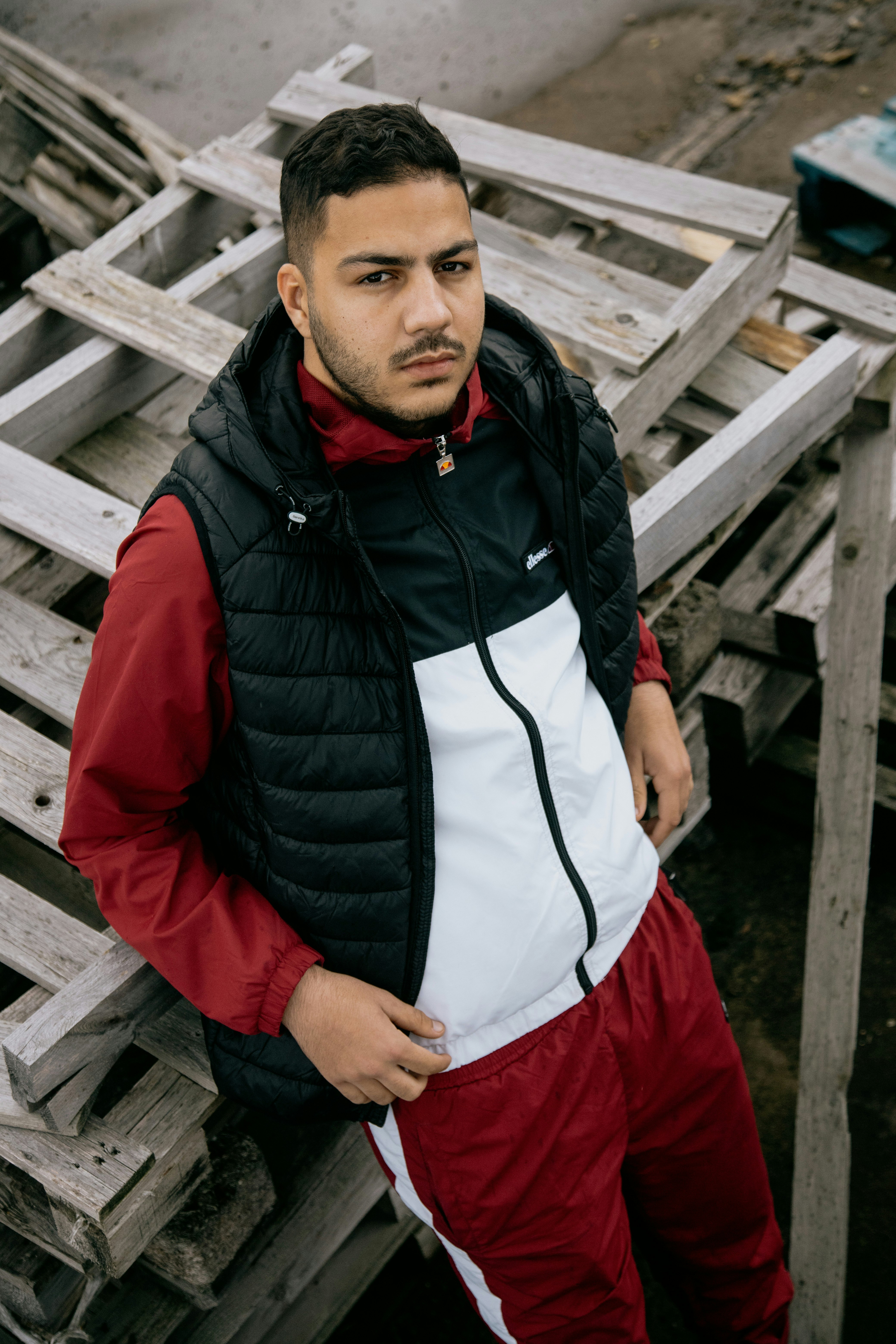 man in black and red zip up jacket standing and smiling